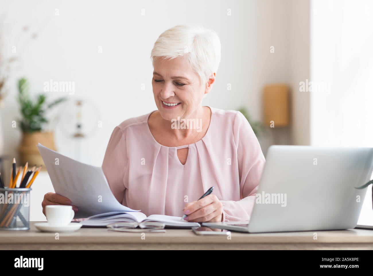 Editor matura la lettura di un testo stampato e creare note Foto Stock