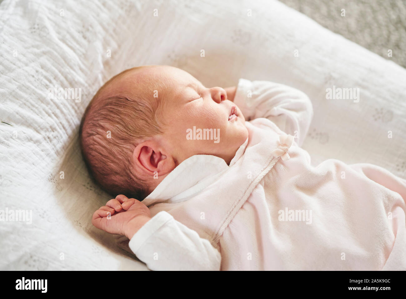 Il bambino dorme su U-cuscino sagomato a casa Foto Stock