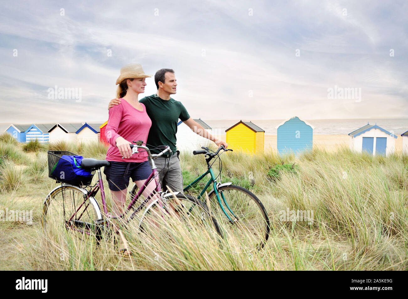 Metà adulto giovane con le biciclette a costa, Southwold, Suffolk, Regno Unito Foto Stock