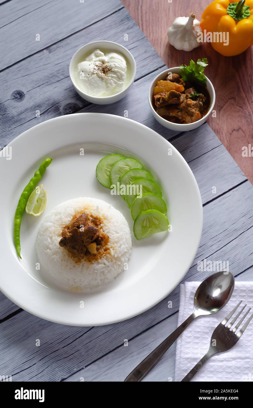 Il cibo indiano: Agnello curry con riso sulla tavola catalogo shot.90° vista dall'alto. Foto Stock