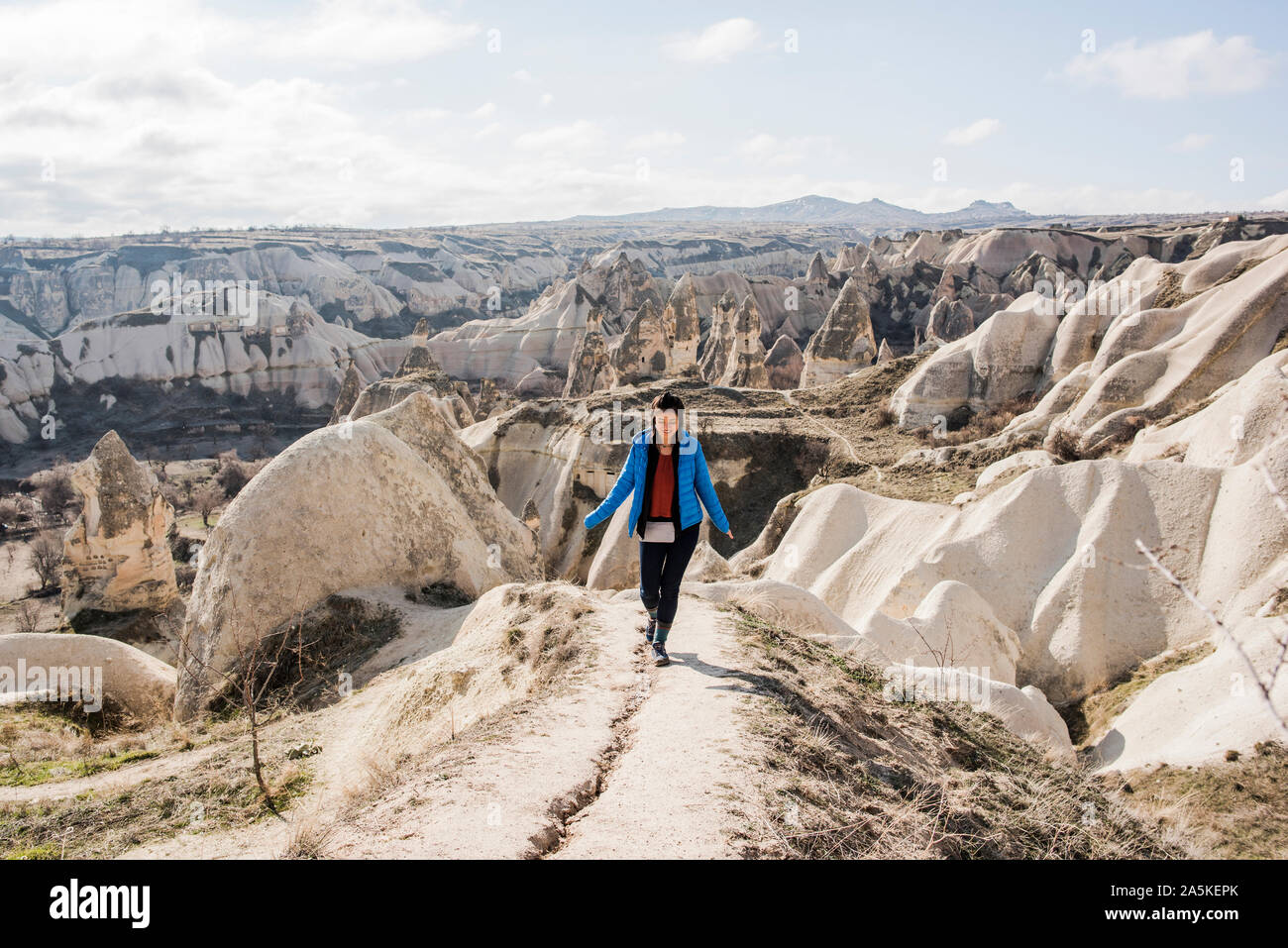 Donna escursionismo in Valle rocciosa, Göreme, Cappadocia, Nevsehir, Turchia Foto Stock