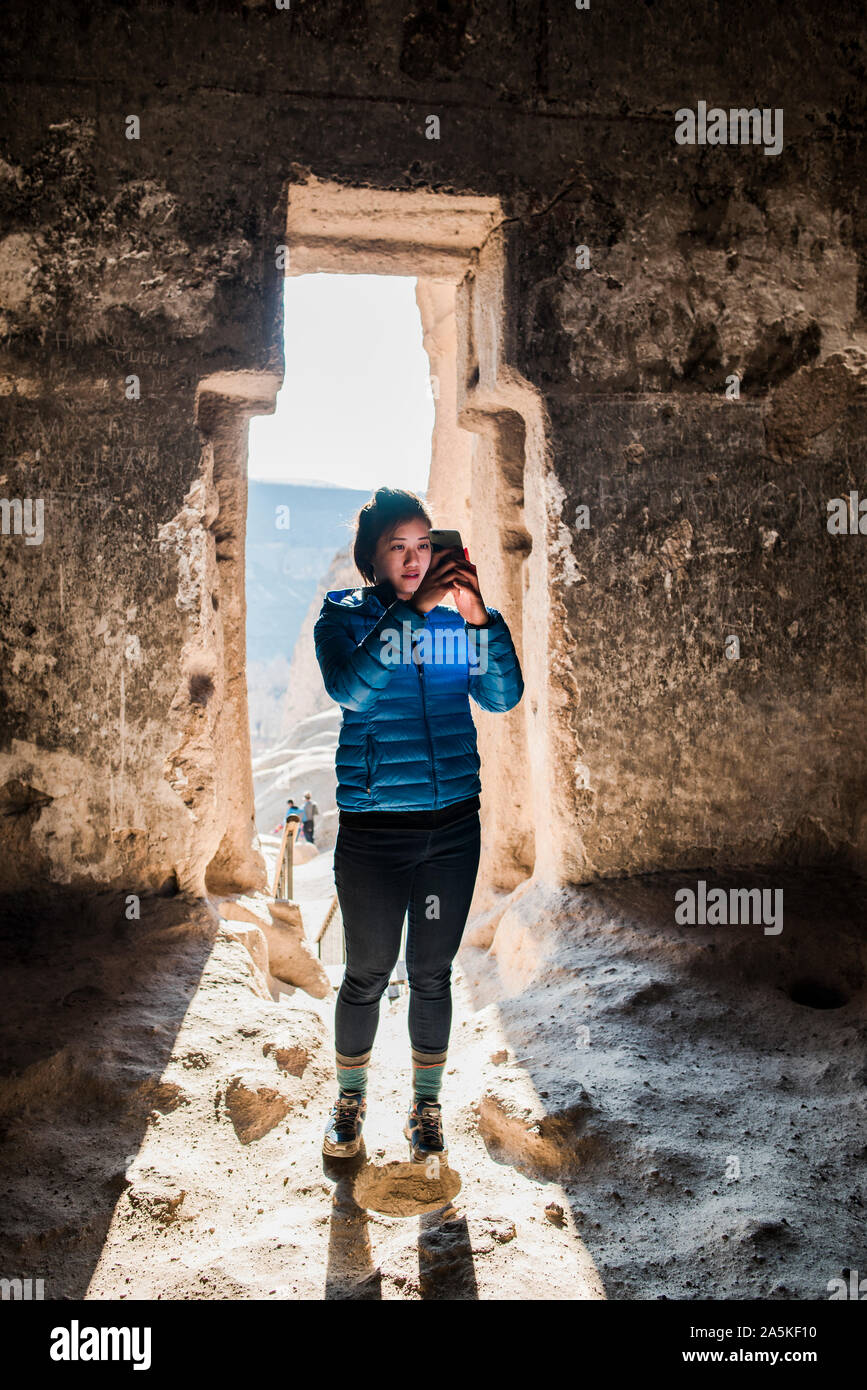 Donna prendendo fotografia nel monastero di Selime, Göreme, Cappadocia, Nevsehir, Turchia Foto Stock