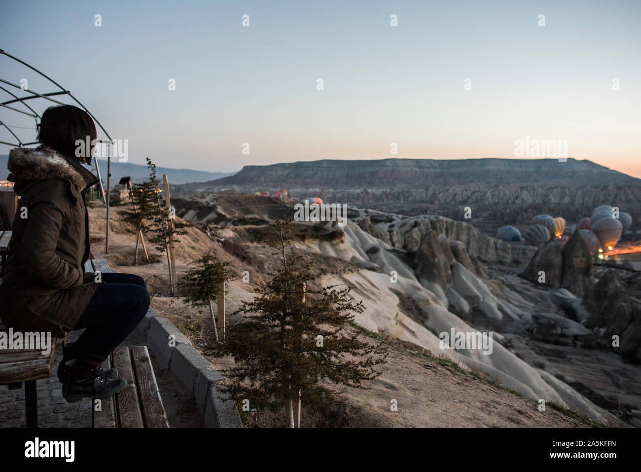 Donna godendo la visualizzazione e la visualizzazione delle mongolfiere in valle di Göreme, Cappadocia, Nevsehir, Turchia Foto Stock