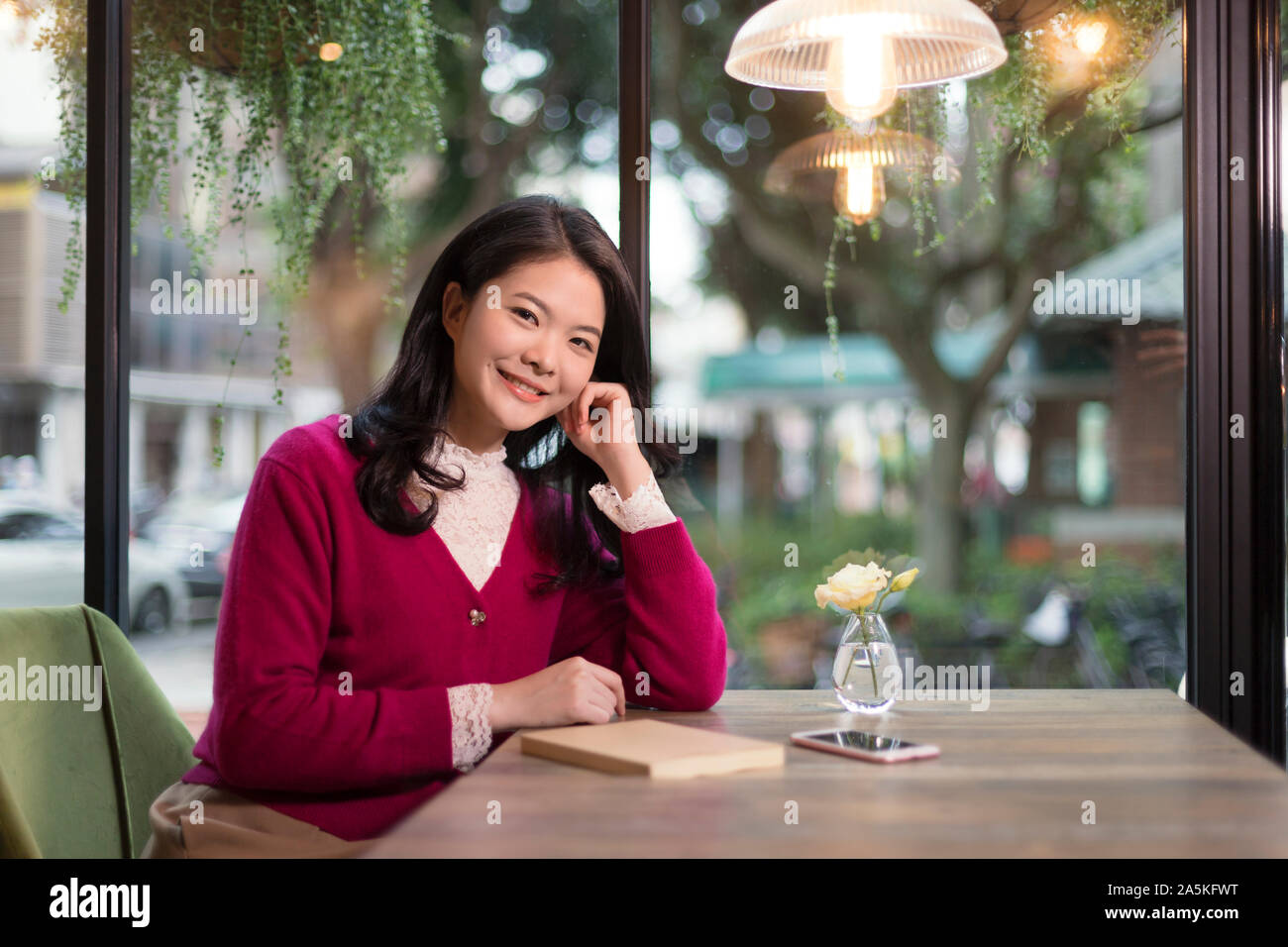 Donna sorridente in seduta cafe Foto Stock