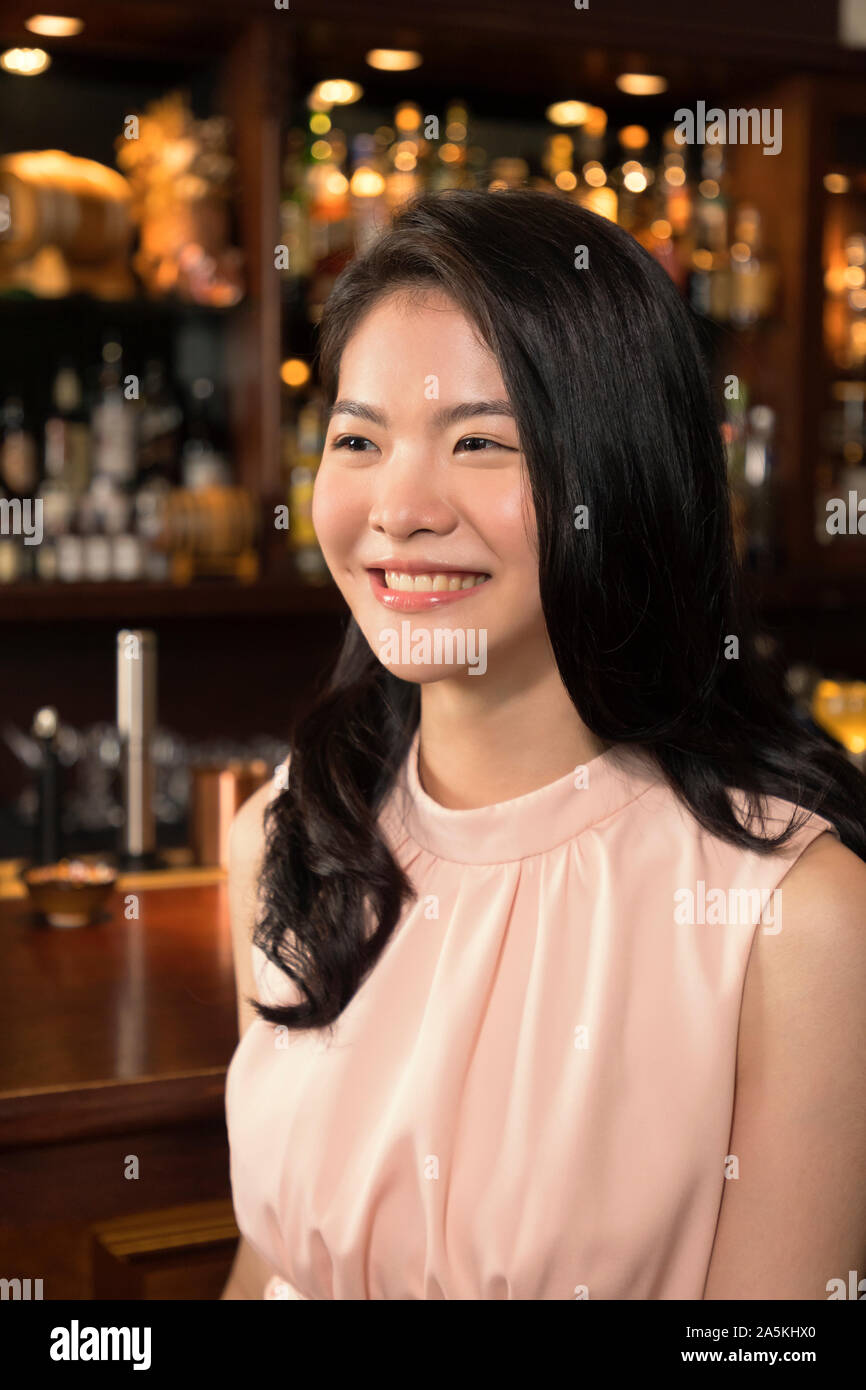 Sorridente giovane donna la tostatura in banco bar Foto Stock Sorridente giovane donna la tostatura in banco bar Foto Stock