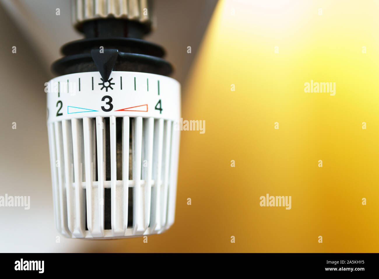 Valvola del termostato del radiatore insieme al numero tre icona (posizione centrale), simbolo per risparmiare soldi a spese di riscaldamento o mezzo di impostazione della temperatura, closeup, Foto Stock