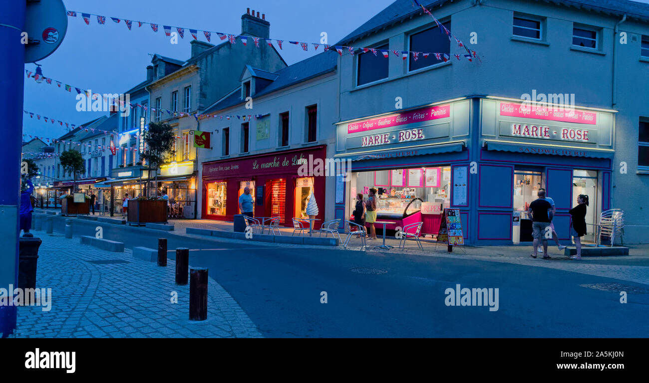 Strada di ristoranti al crepuscolo in Port en bessin, Normandia, Francia Foto Stock