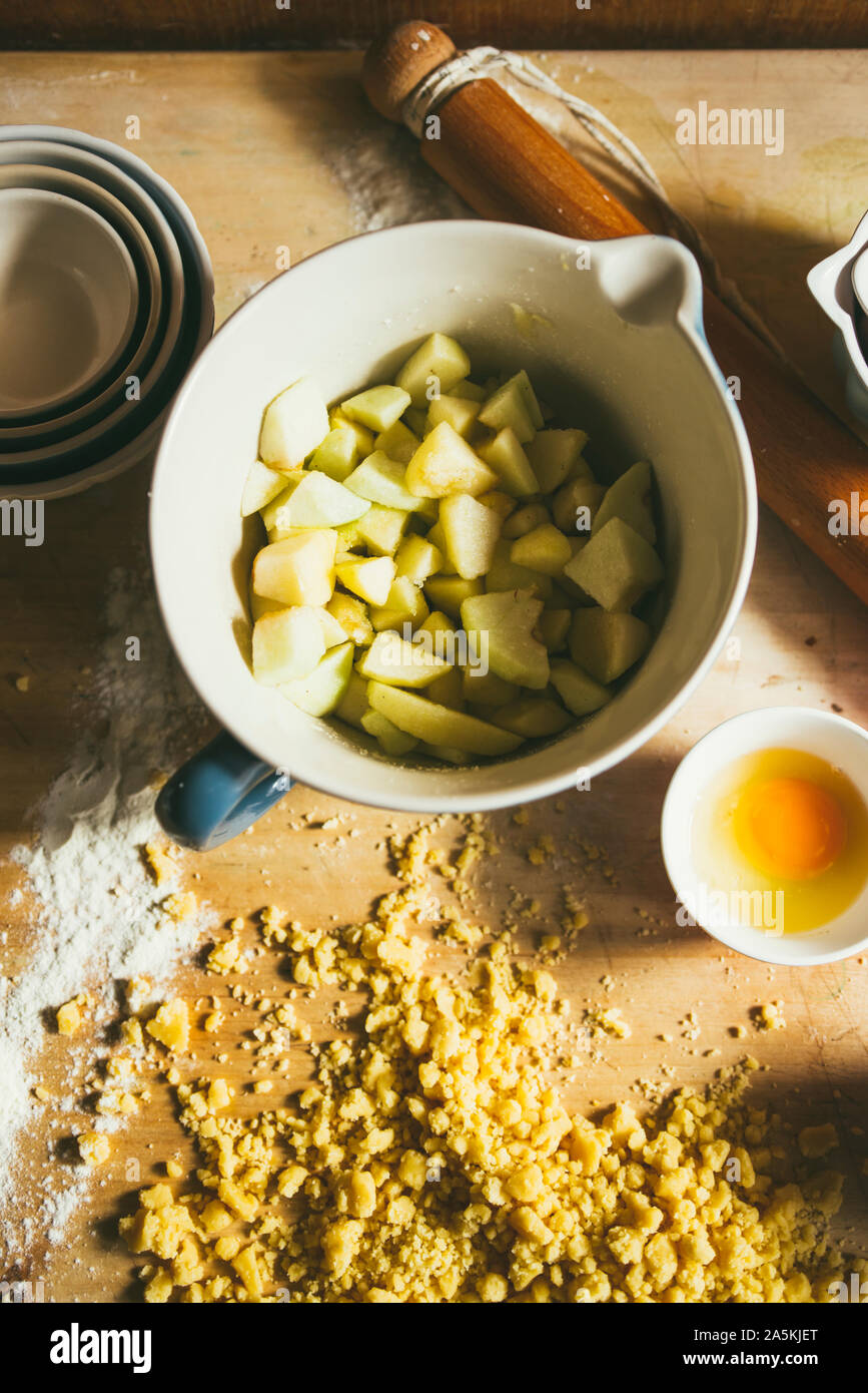 Serie di fotografia come fare un mele crumble , dagli ingredienti alla fine torta, ambiente rustico, Apple vengono tagliate in pezzi, miscelata con br Foto Stock