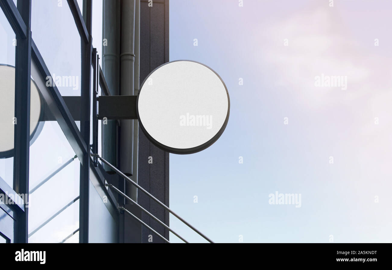 Bianco bianco esterno scatola rotonda mockup su un edificio di vetro Foto Stock