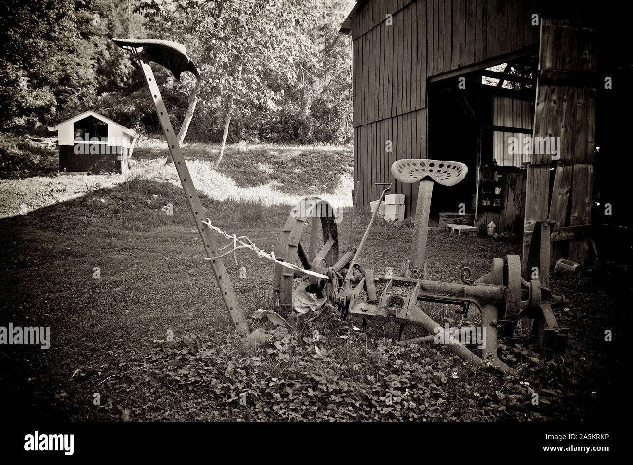 Vecchio arrugginito falce fieno al di fuori di un fienile. Foto Stock