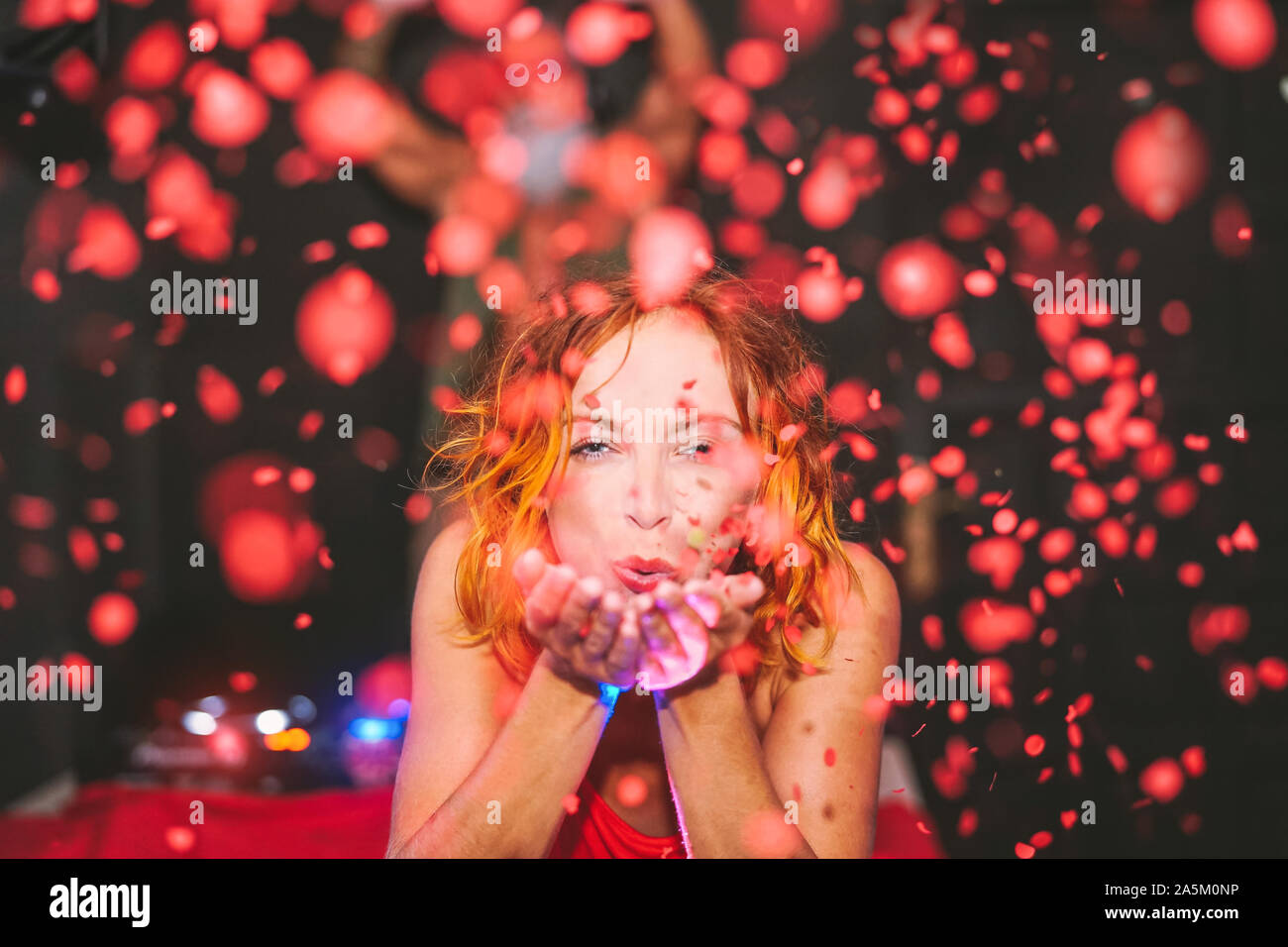 Donna felice gettando coriandoli in discoteca - ragazza giovane con momenti divertenti a celebrare in bar Foto Stock