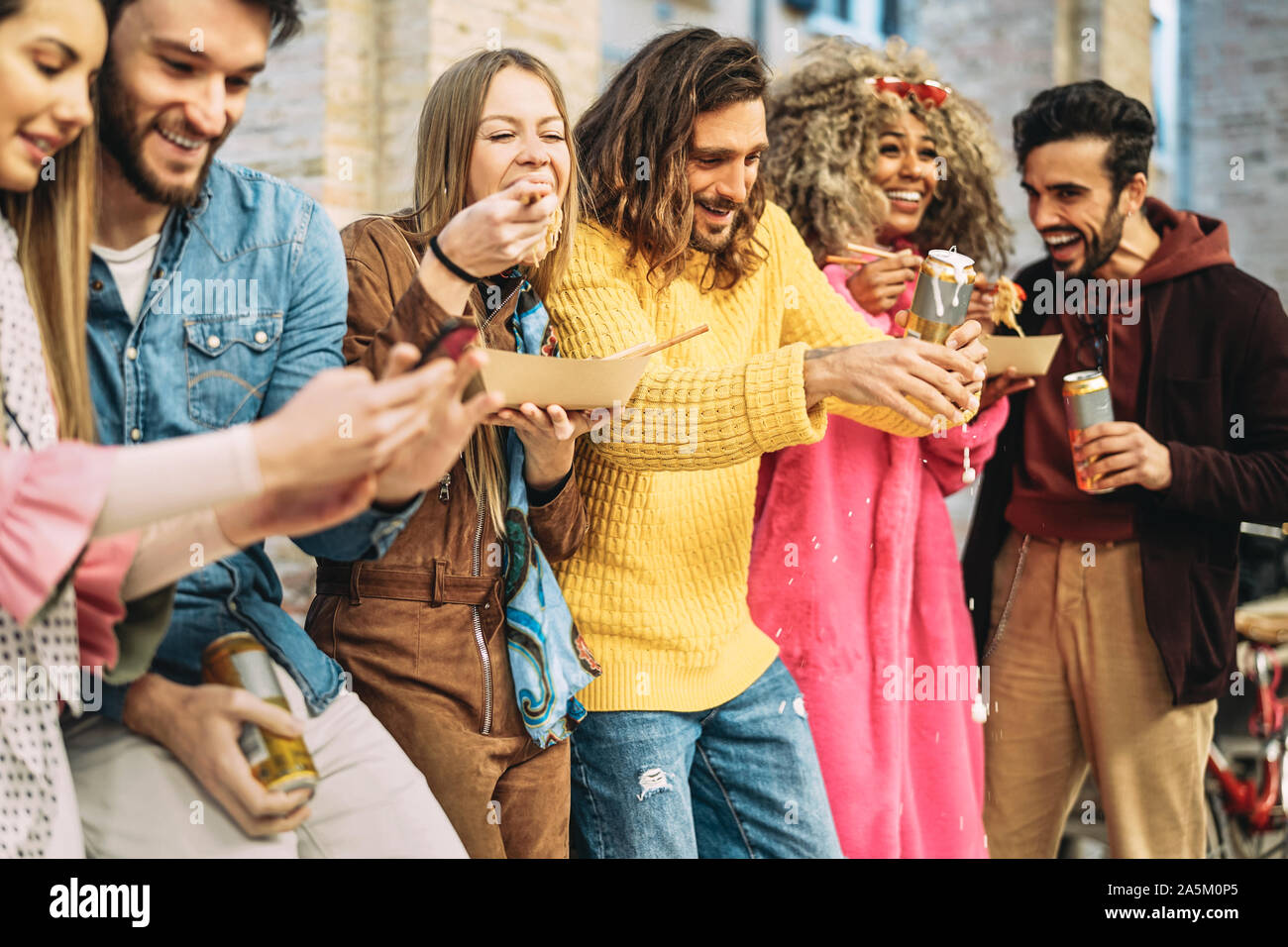 Gruppo di amici felici di mangiare cibo asiatico e bere birre nella città millenaria - i giovani per divertirsi e ridere insieme all'aperto Foto Stock