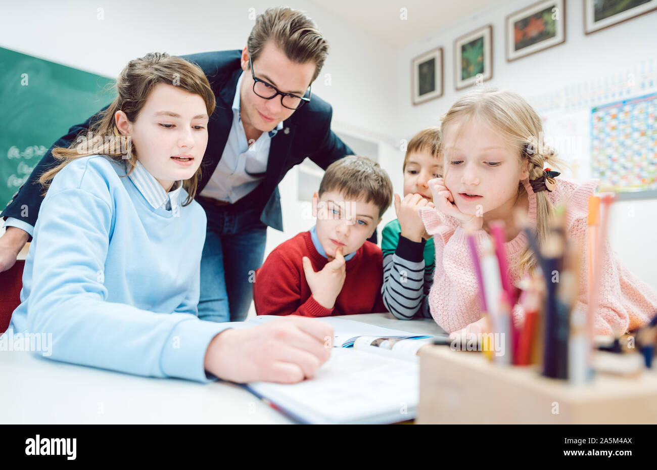 Per la sessione di gruppo nella scuola di classe con tutti gli studenti lavorano insieme Foto Stock