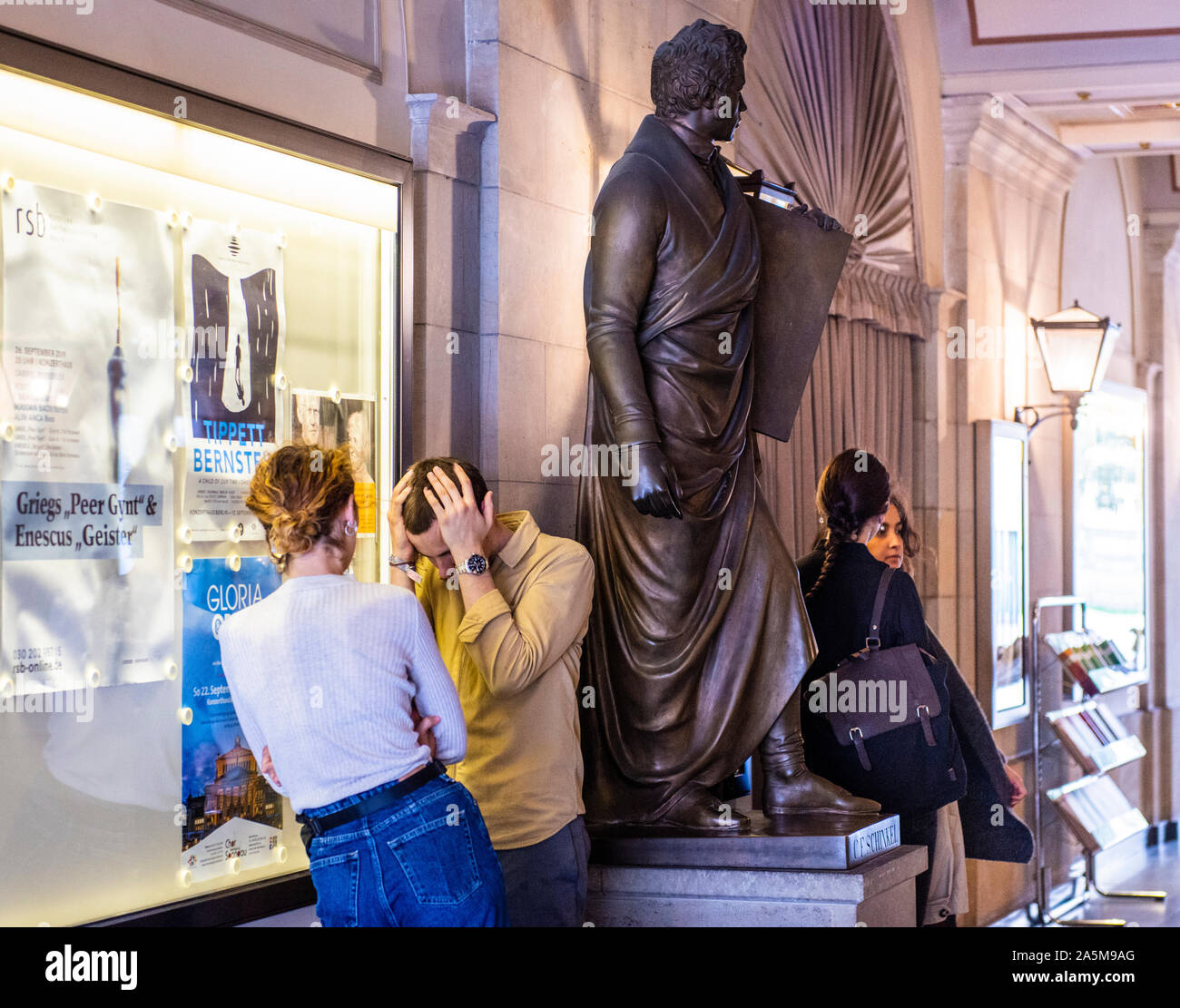 Donna consolante sconvolto l uomo con le mani sulla testa accanto alla statua di Berlino, Germania Foto Stock