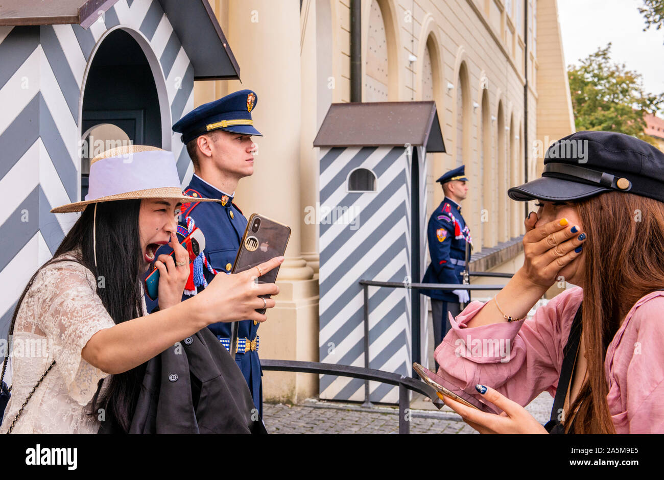 Turisti asiatici di ridere e di assunzione di fotografia con protezione all'entrata del Castello di Praga, Repubblica Ceca Foto Stock