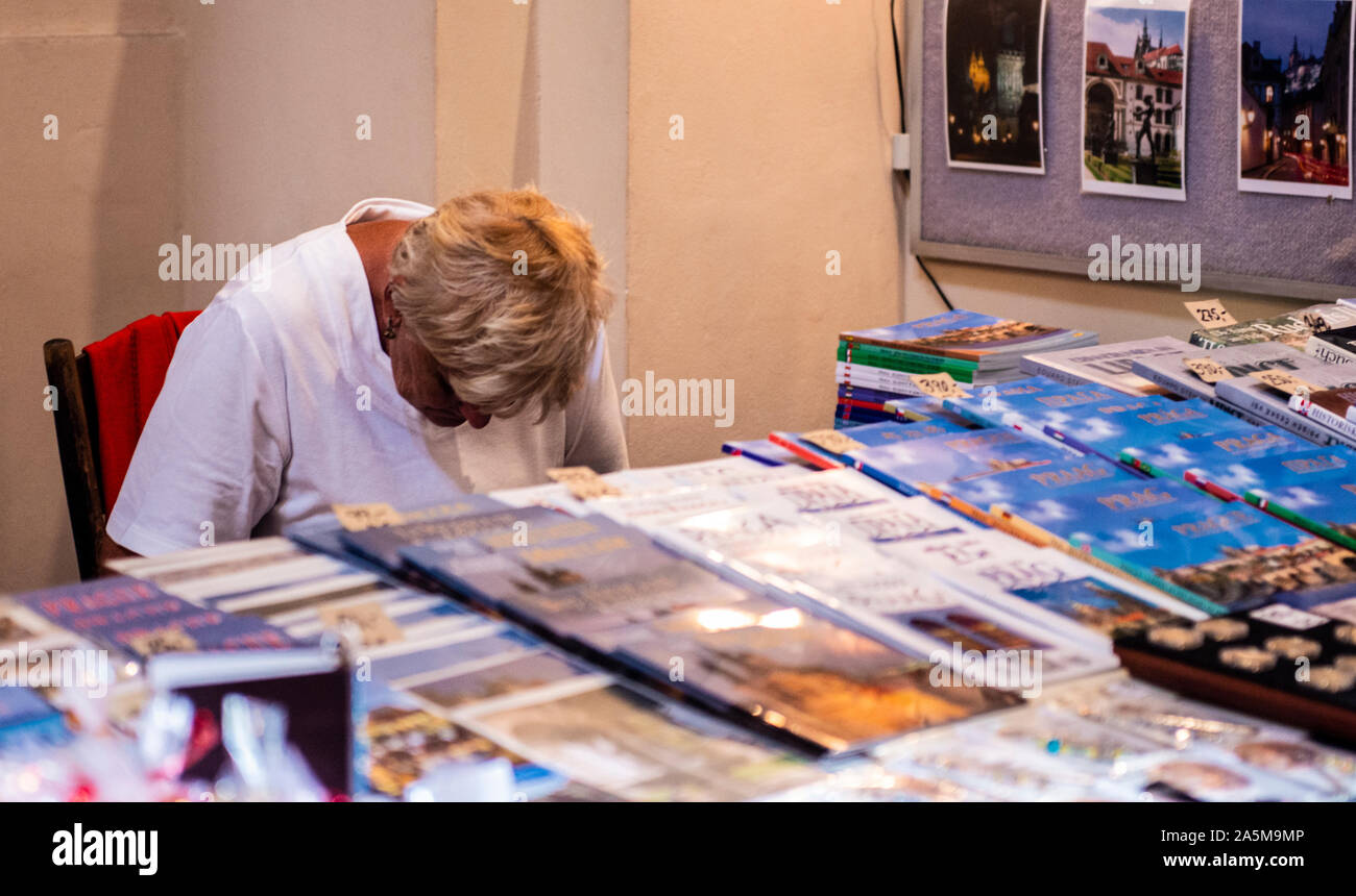 Donna vendita di viaggi libri guida alla pressione di stallo, la Piazza della Città Vecchia di Praga, Repubblica Ceca Foto Stock