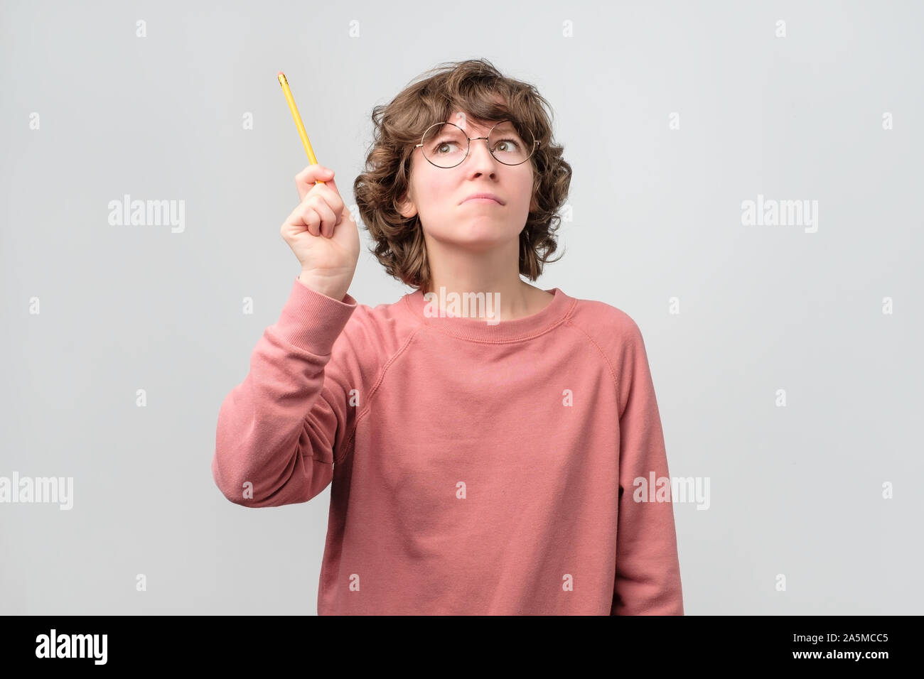 Donna giovane studente tenendo il dito con la matita verso l'alto. Formazione Online Foto Stock