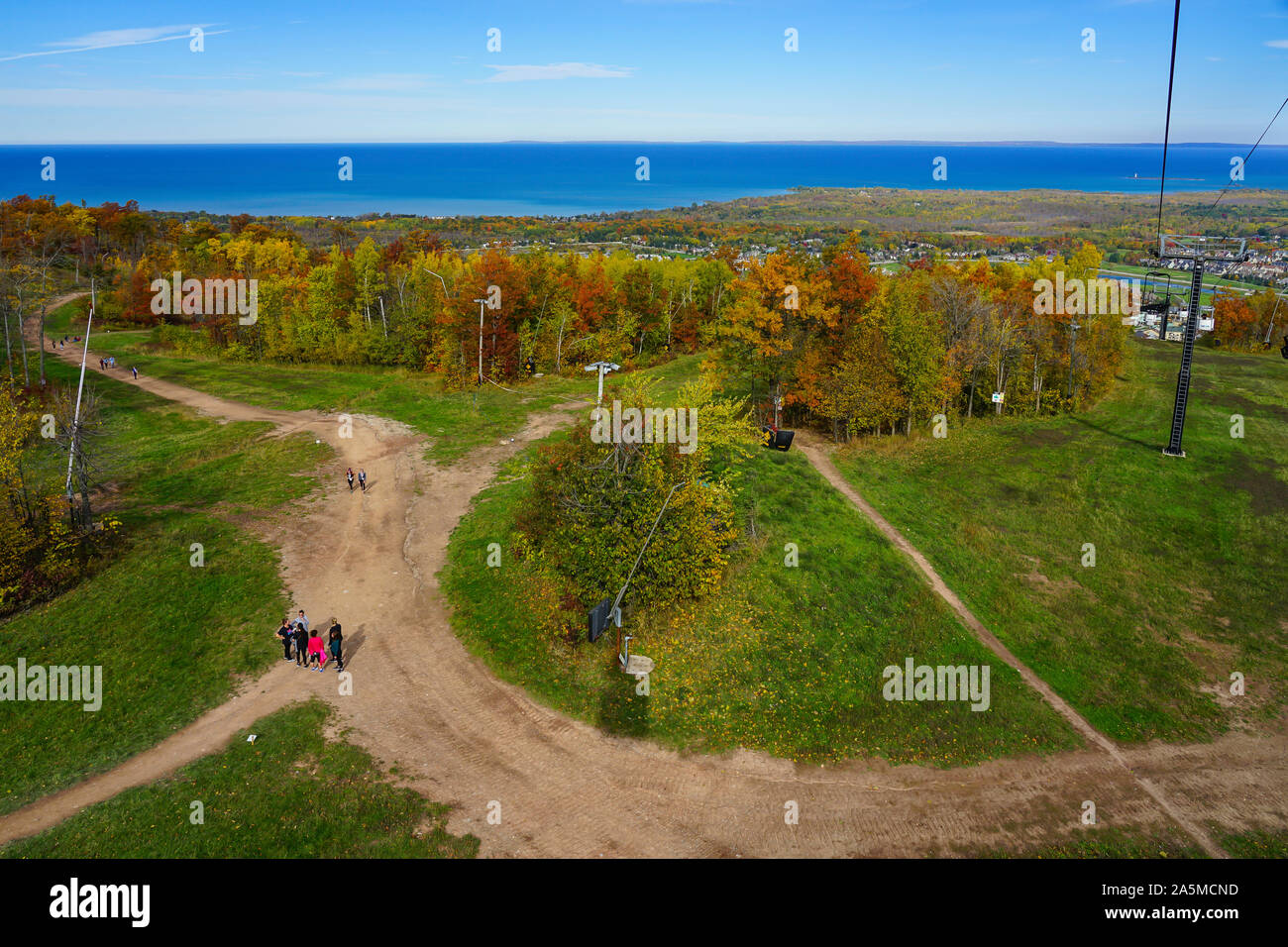 Gli escursionisti salire la montagna in su il villaggio sicuro al Blue Mountain Village resort durante il periodo autunnale in Collingwood, Ontario, Canada, Foto Stock