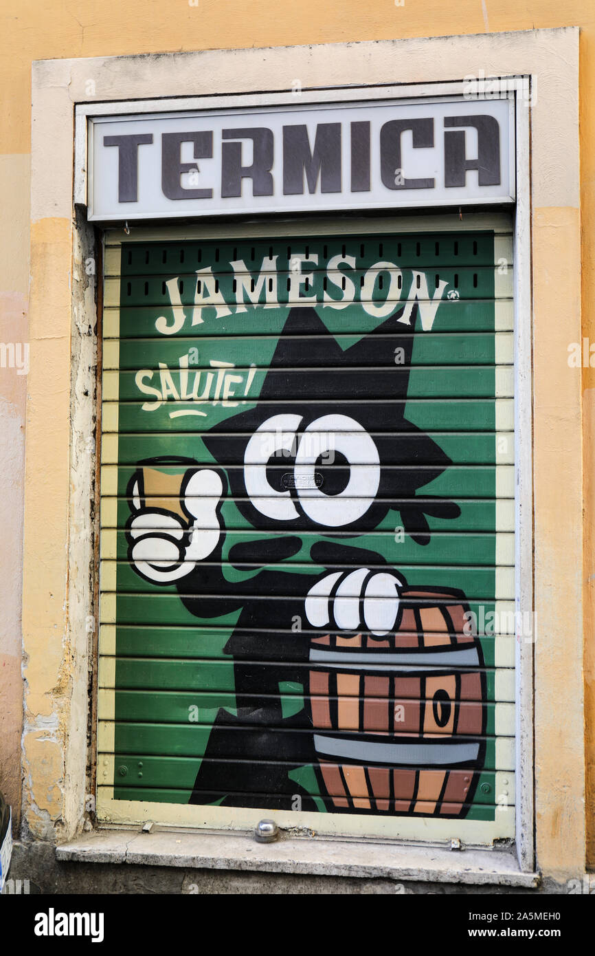 Jameson Whiskey murale annuncio su un acciaio porta avvolgibile nel quartiere di Trastevere a Roma, Italia Foto Stock