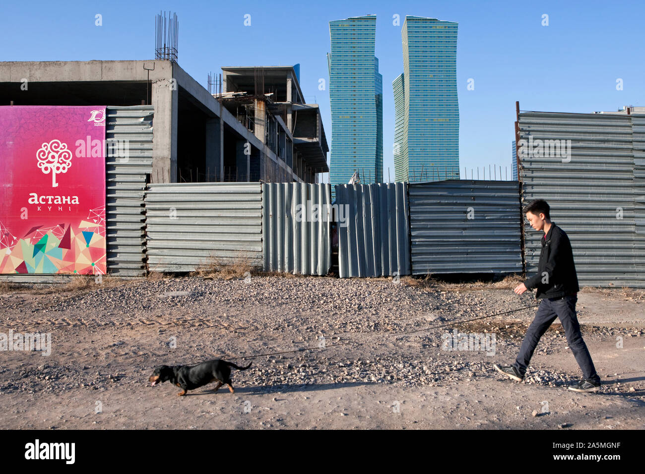NUR-SULTAN - un uomo cammina il suo cane nella parte nuova della città Foto Stock
