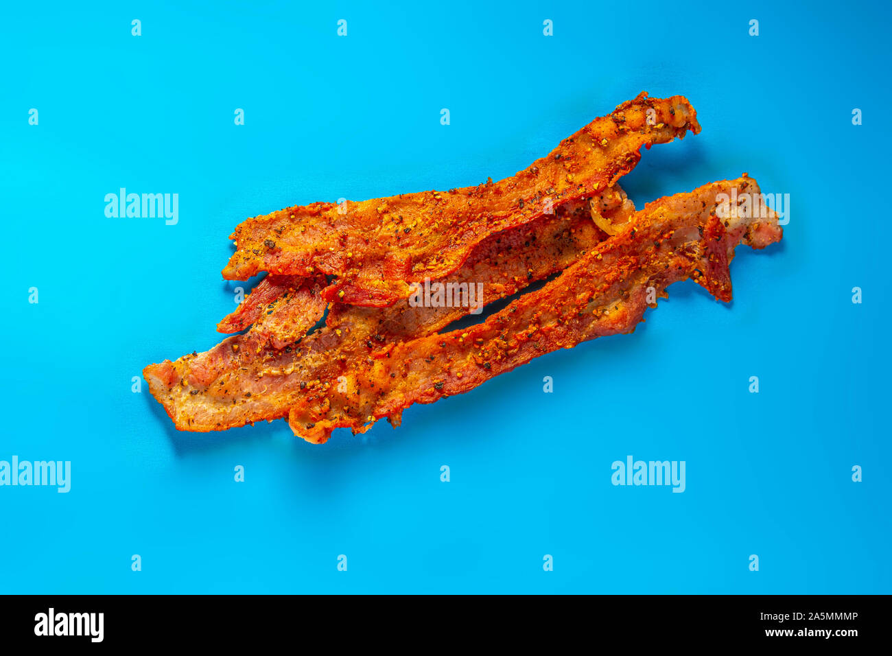 Strisce di pancetta su uno sfondo blu Foto Stock