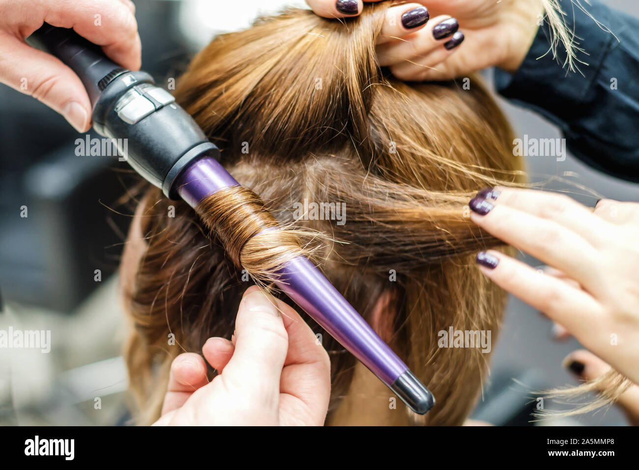 Parrucchiere professionale è la torsione i capelli con un ferro  arricciacapelli in salone di bellezza vicino. Concetto stilista femmina  Foto stock - Alamy