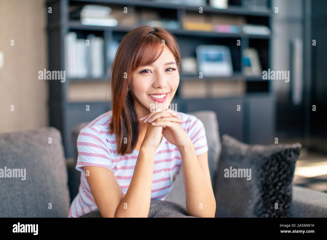 Bella giovane donna sorridente nel soggiorno Foto Stock