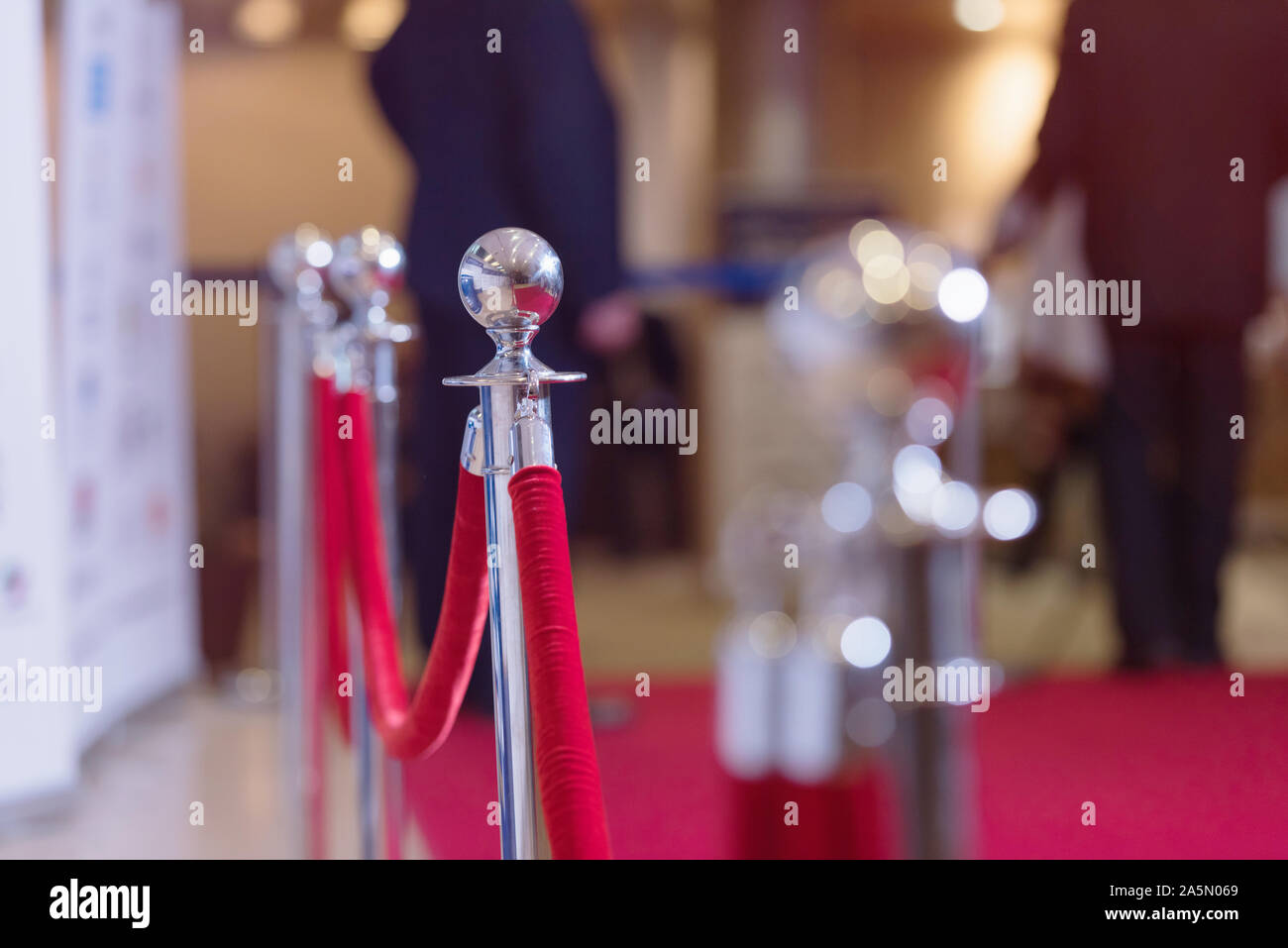 Candelieri in argento con una corda rossa. Barriera, racchiuso area VIP, entrata protetta, evento privato di lusso di concetto di gala. Foto Stock