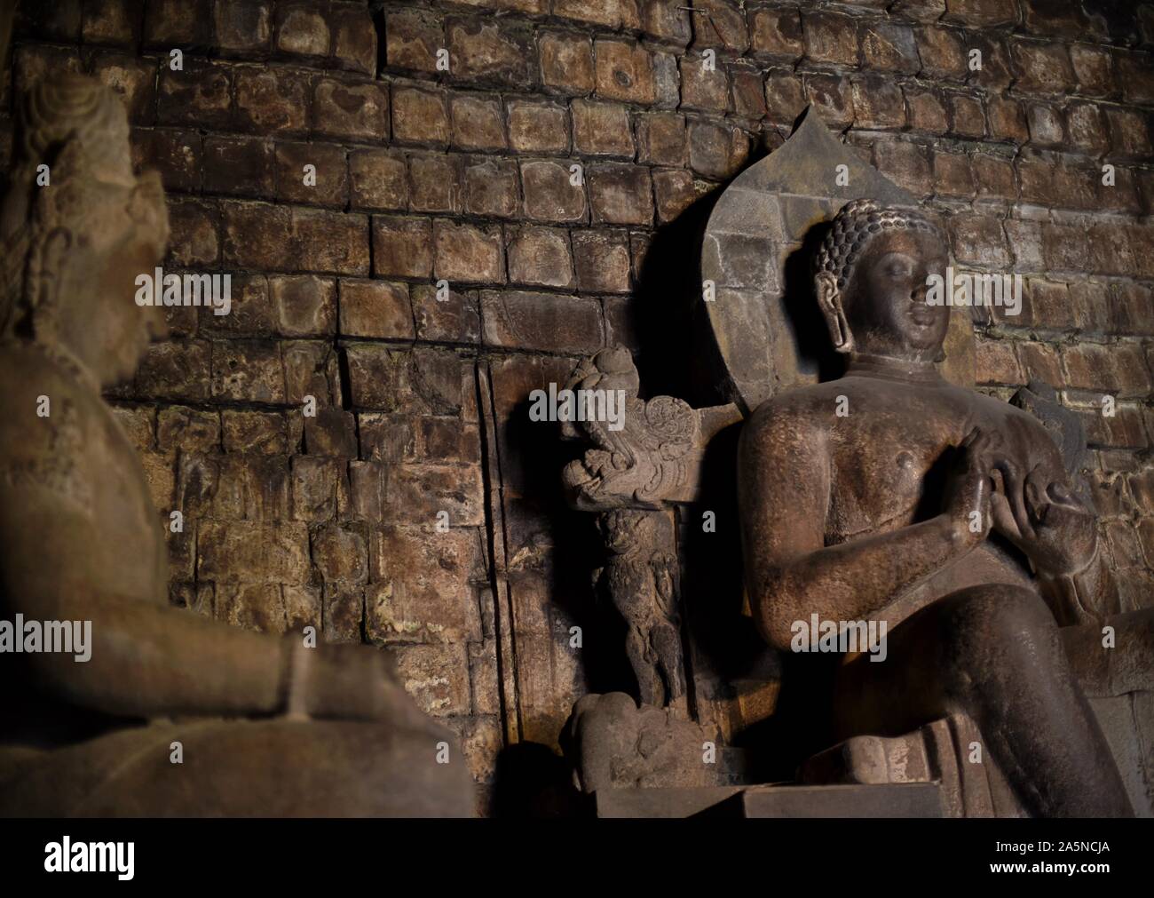 La statua di Dhyani Buddha Vairocana (a destra) all'interno del tempio Mendut nel centro di Giava, in Indonesia. Foto Stock