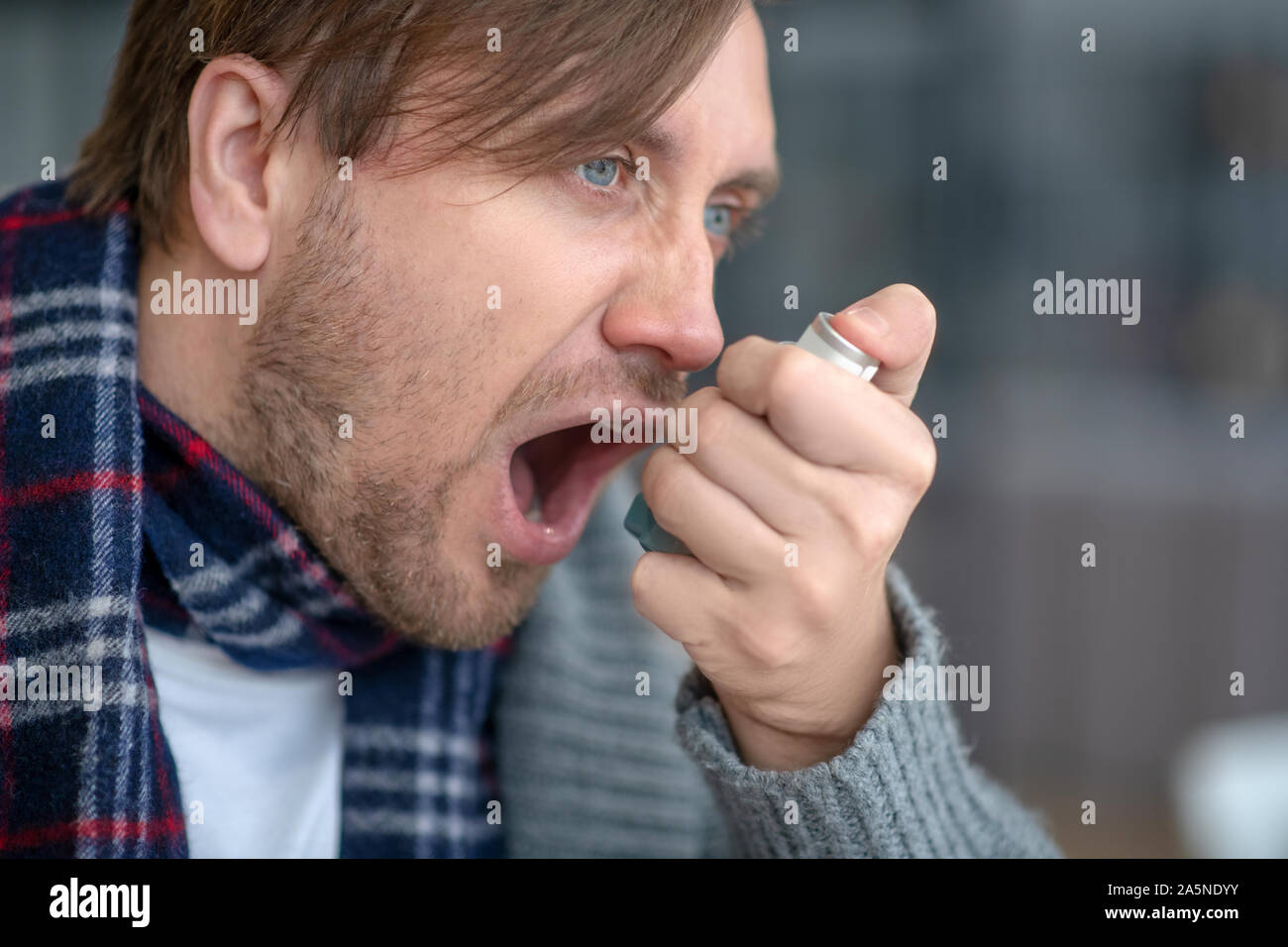 Blue-eyed man sensazione terribile pur avendo attacchi di asma Foto Stock