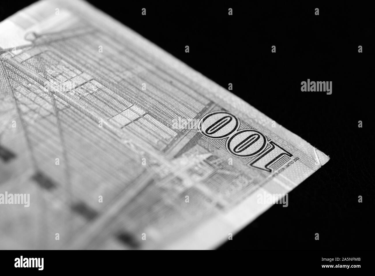 Un centinaio di dollari di Hong Kong banconota su sfondo scuro vicino. In bianco e nero Foto Stock