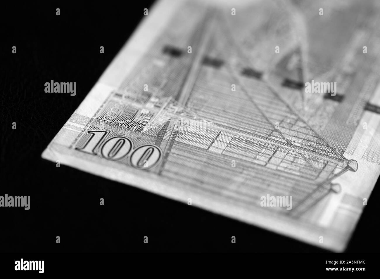 Un centinaio di dollari di Hong Kong banconota su sfondo scuro vicino. In bianco e nero Foto Stock