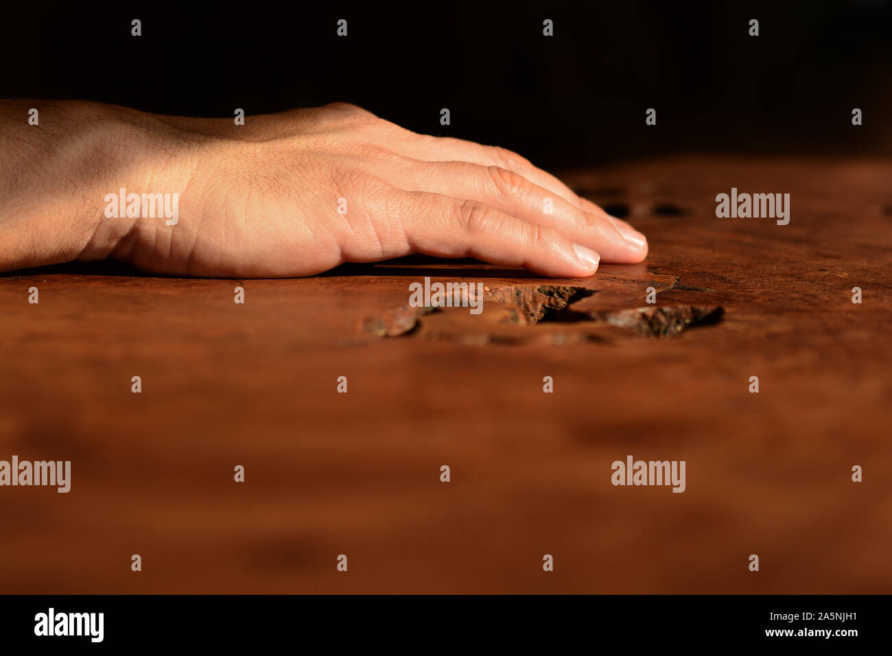 Maschio lato toccando un tavolo in legno Foto Stock