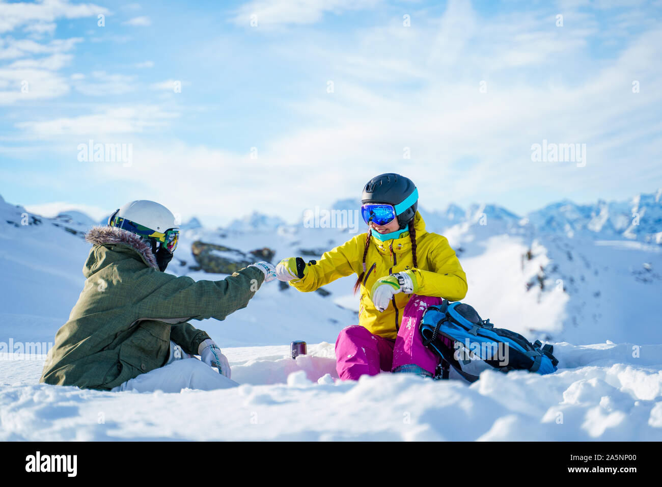 Immagine di due sportivi handshake facendo seduti sulla neve resort nel pomeriggio Foto Stock