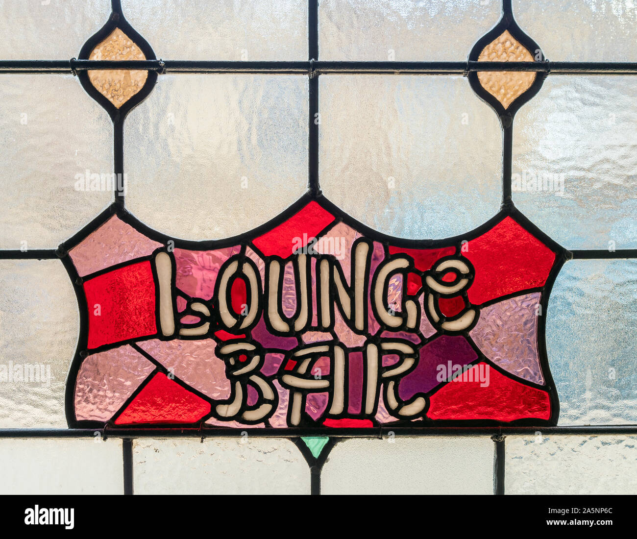 Finestra di vetro colorato che mostra LOUNGE BAR segno in un vecchio pub. Foto Stock