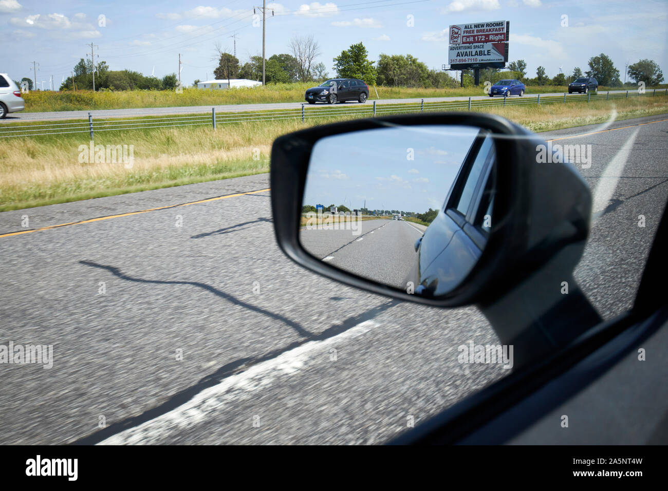 Cerca in auto sul lato parafango-specchio retrovisore guidando lungo la interstate indiana USA Foto Stock