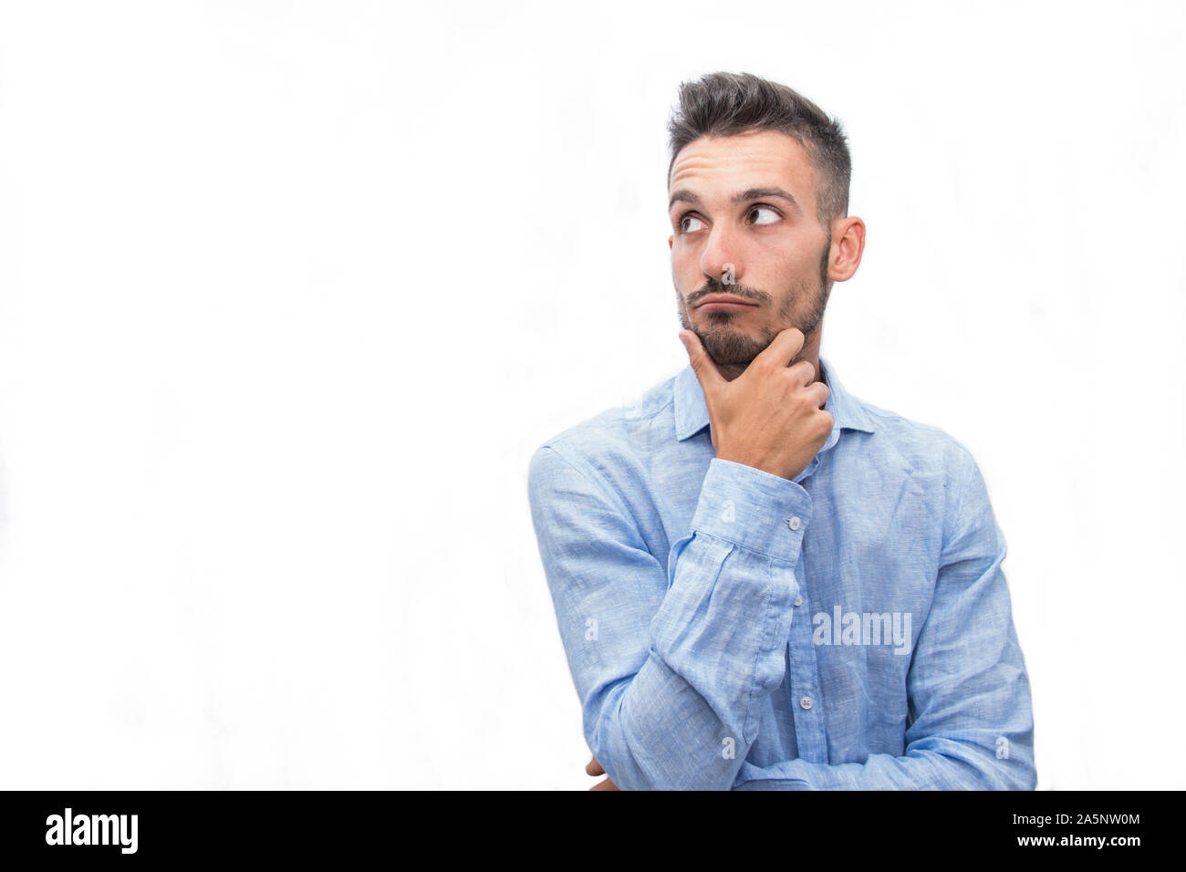 Giovane uomo isolato pensando su uno sfondo bianco Foto Stock