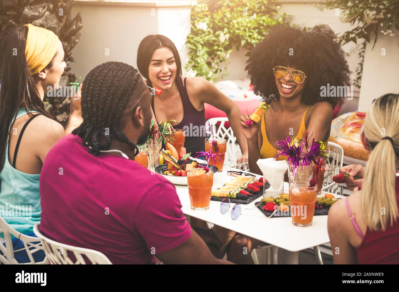 Gruppo di amici gustando pasti e divertimento all'aperto Foto Stock