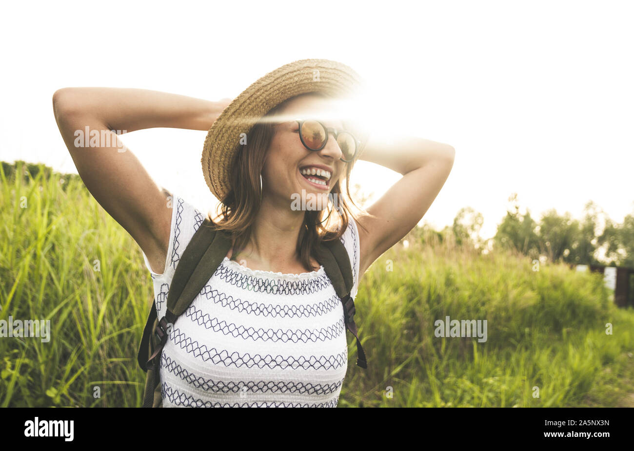 Bella donna spensierata nei campi sorriso alla luce del sole. Foto Stock