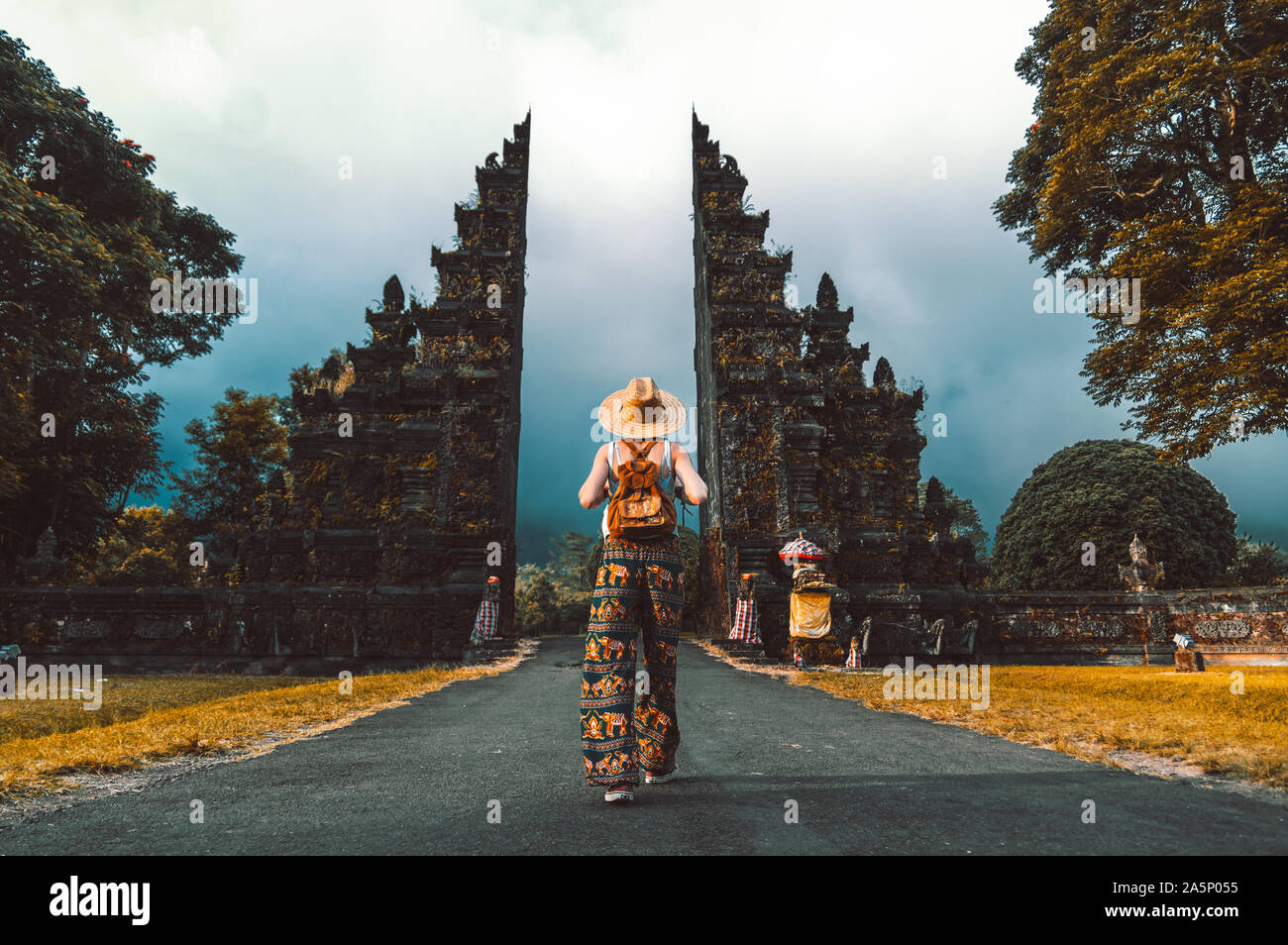 Donna turistica con zaino in vacanza a piedi attraverso il tempio indù di Bali in Indonesia Foto Stock