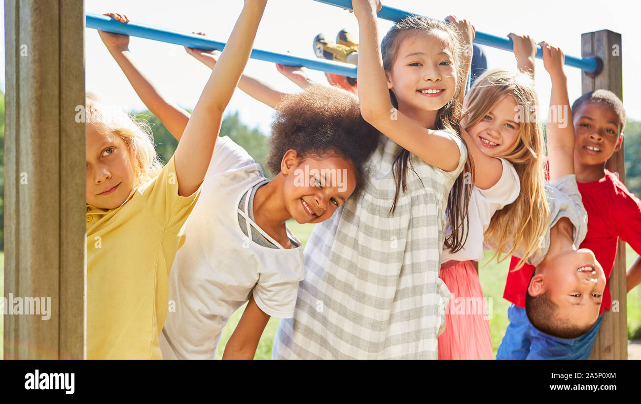 Bambini multiculturale come amici mentre facendo ginnastica in una giungla palestra Foto Stock