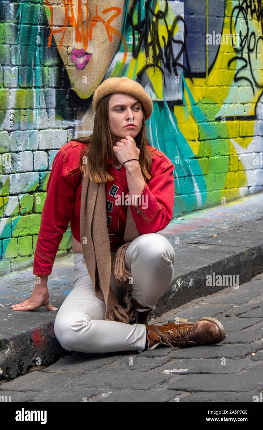 Donna che posano per una fotografia in Hosier Lane pareti ricoperte di graffiti e arte di strada Melbourne Victoria Australia. Foto Stock