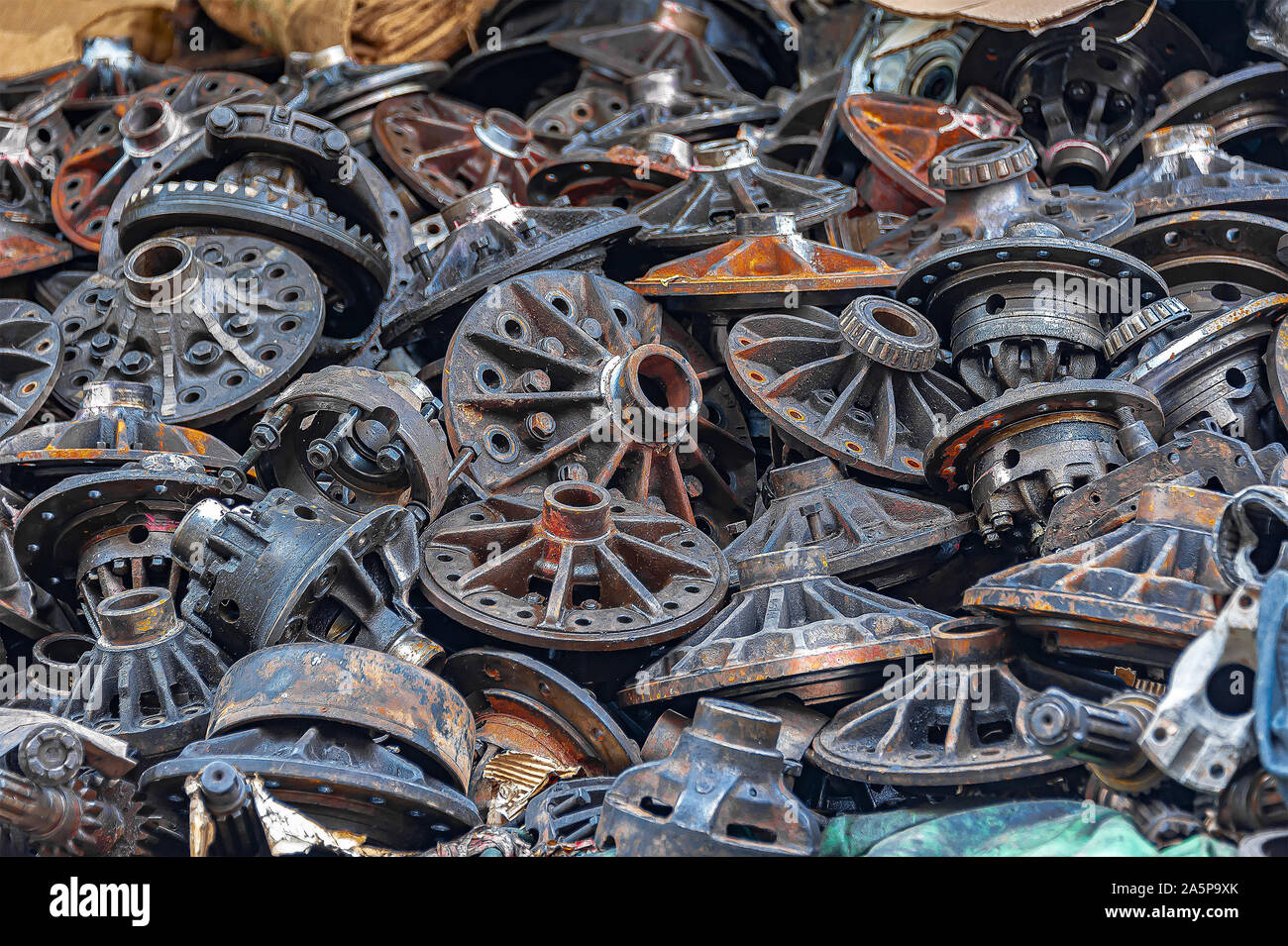 Close-up di vecchie parti del motore, i dadi e i bulloni impilati per la vendita in un metallo scrapyard. Foto Stock