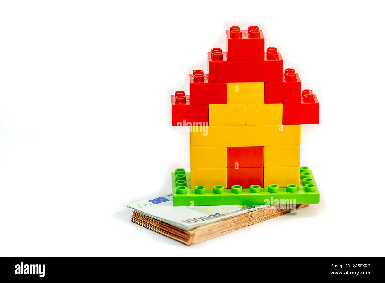 Modello di casa con la pila di banconote in euro, il denaro. Foto Stock
