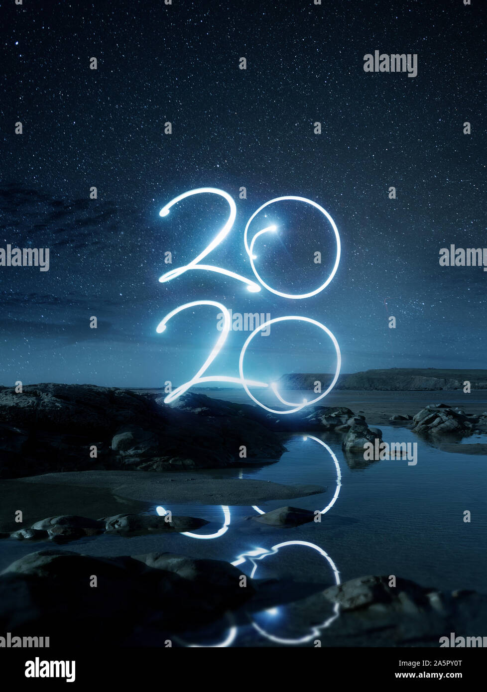 Felice Anno Nuovo2020 effetto luce riflettente di scrittura in acqua su una spiaggia di notte. Una lunga esposizione paesaggio fotografico composito. Foto Stock