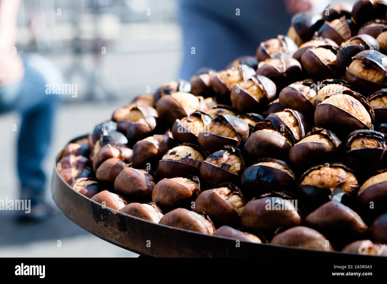 Primo piano di alcune castagne arrostite sulla vendita in un cibo di strada stand in Roma, Italia Foto Stock