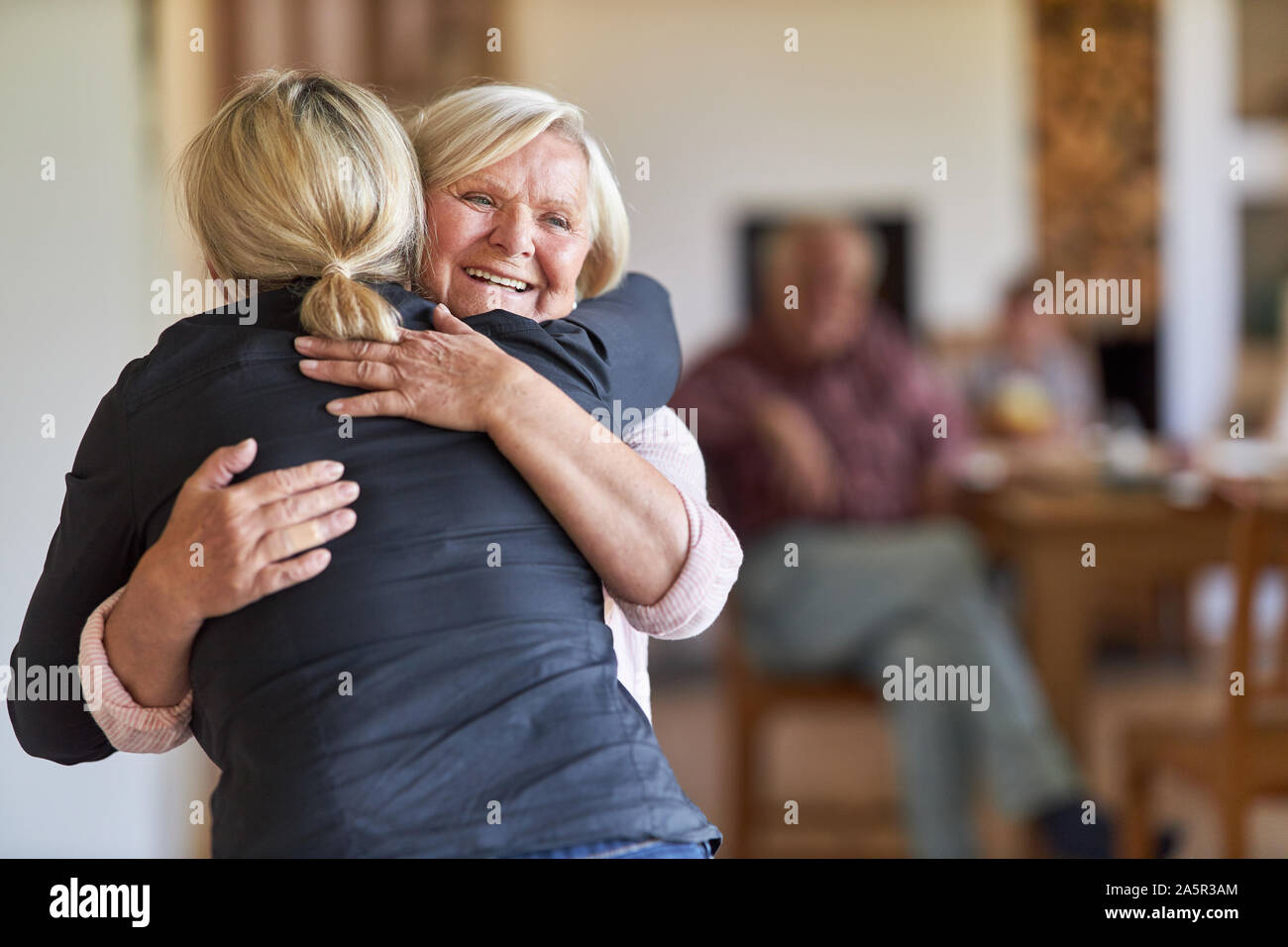 Visite figlia felice madre nella casa di cura e abbraccia nel suo messaggio di saluto Foto Stock