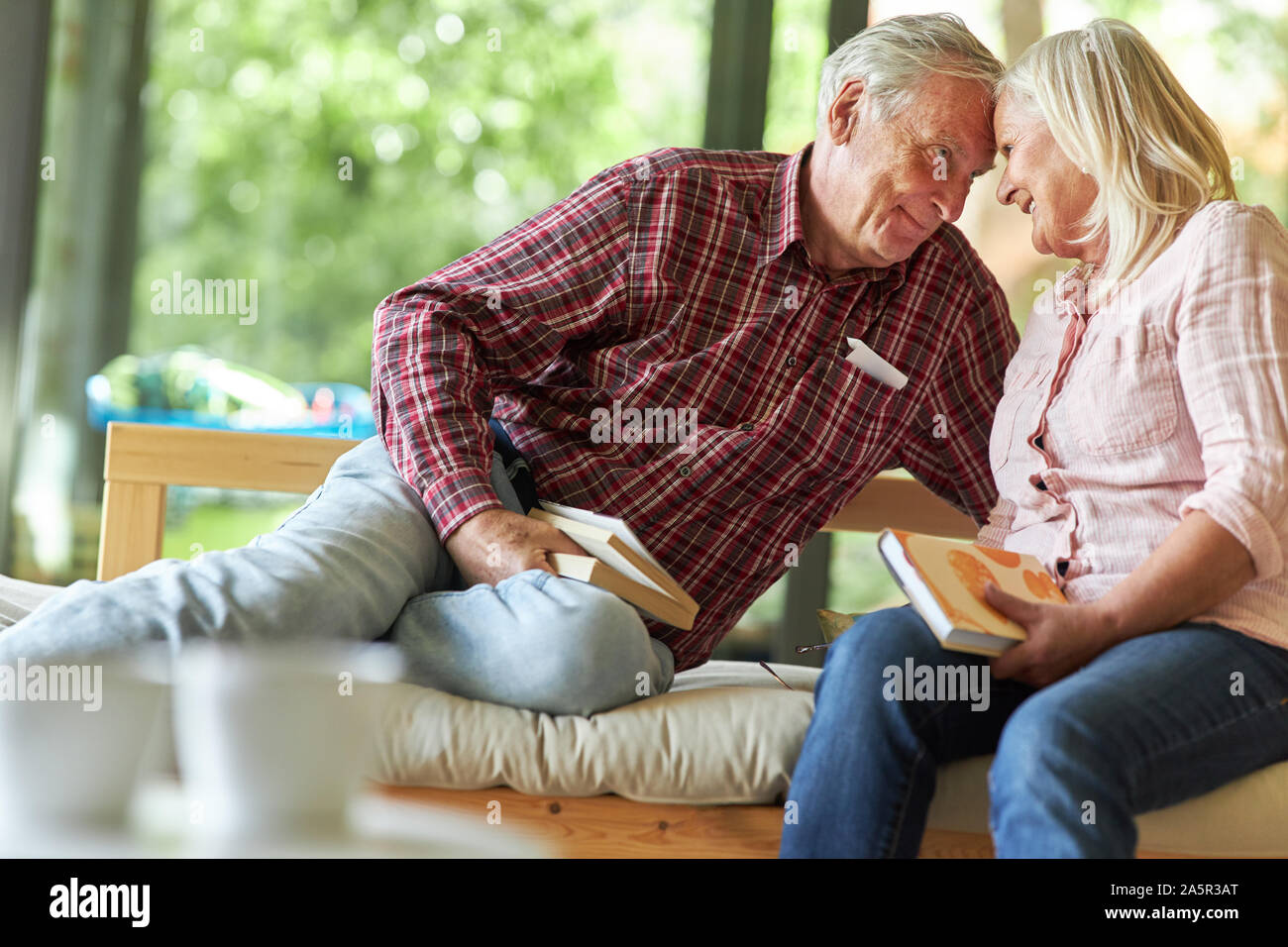 Ritirato coppia senior si rilassa in salotto con libri Foto Stock