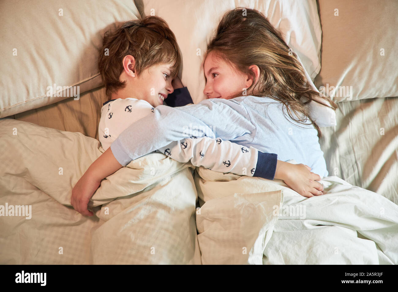 Fratello e Sorella pacificamente coccola insieme nel letto matrimoniale in  camera da letto Foto stock - Alamy