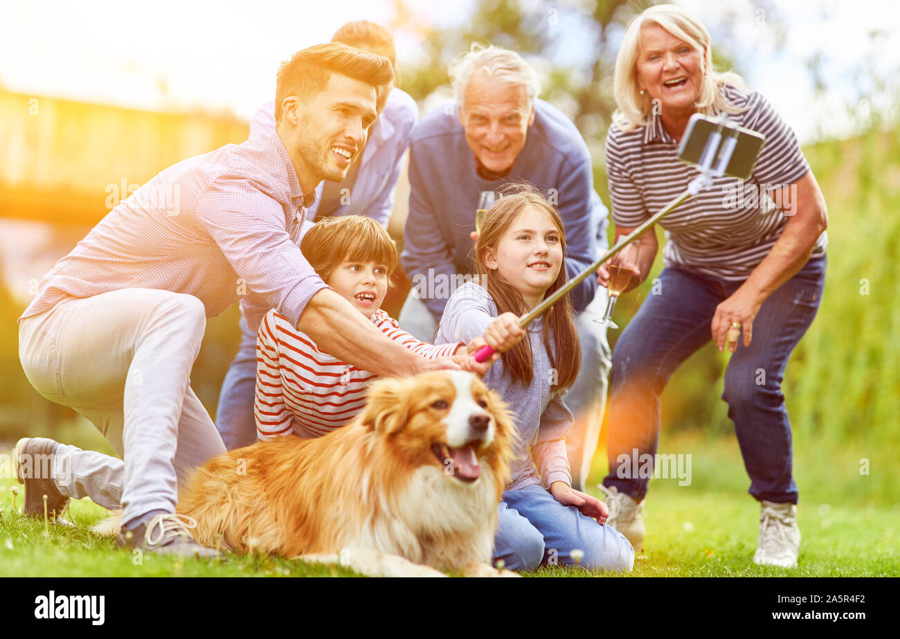 Grande famiglia estesa è rendere selfie in giardino con il cane in estate Foto Stock